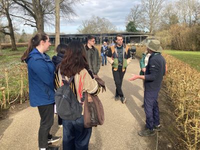 A group of interns in a garden listening to a talk by a volunteer guide.